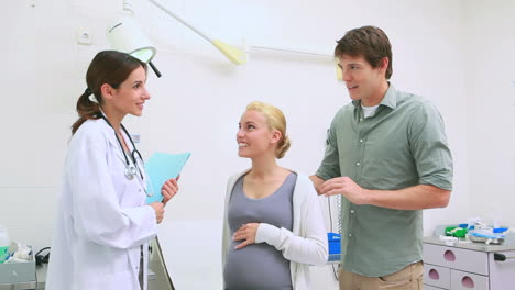 Doctor-talking-to-a-pregnant-woman-and-her-husband