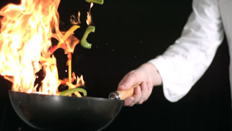 Der-Koch-Rührt-Das-Feuer-Um