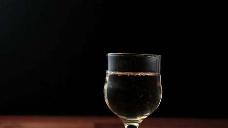 Glass-of-white-wine-being-poured-with-bottle-in-shot