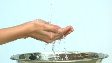 Woman-washing-her-hands-under-stream-of-water-in-a-sink-