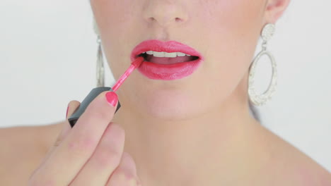 Mujer-Aplicando-Brillo-De-Labios-Rosa