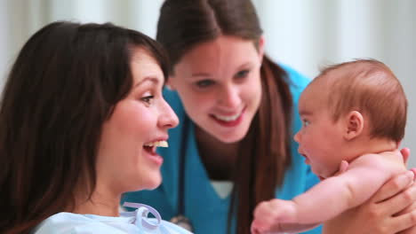 Woman-holding-her-baby-next-to-a-nurse