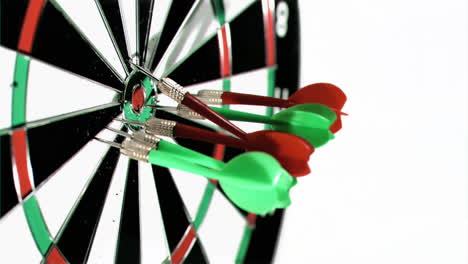 Darts-grouped-together-in-super-slow-motion-being-thrown-on-a-dart-board