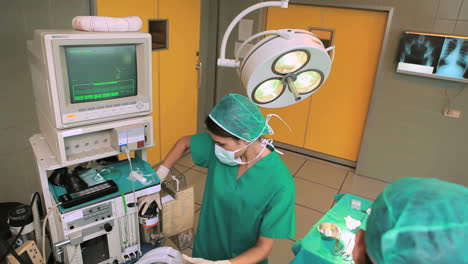 Surgeon-and-a-team-operating-a-patient-while-looking-at-a-monitor