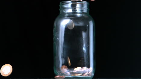 Many-coins-pouring-into-glass-jar