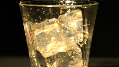 Whiskey-pouring-into-tumbler-with-ice-close-up