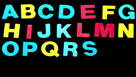 Colourful-alphabet-appearing-on-black-background