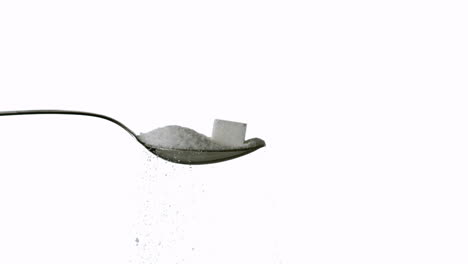 Sugar-spilling-off-spoon-with-sugar-and-sugar-cube