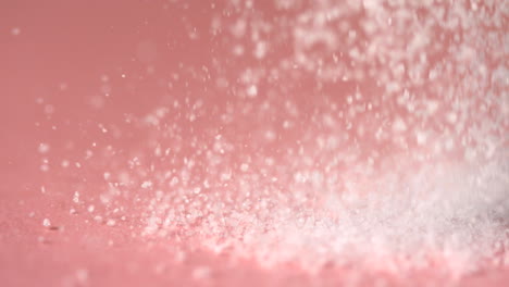 Sugar-falling-onto-pink-surface