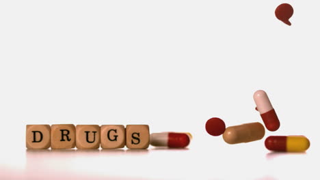 Different-tablets-falling-beside-dice-spelling-drugs