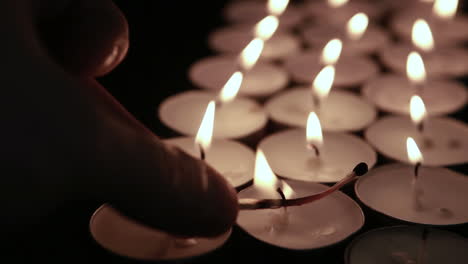 Hand-lighting-tea-light-candles-with-match