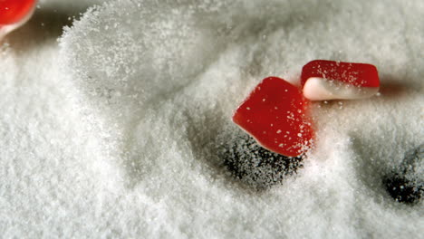 Heart-shaped-candies-falling-in-pile-of-sugar