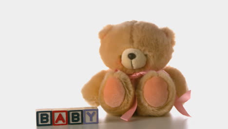 Teddy-bear-falling-besides-baby-blocks