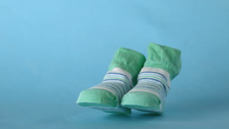 Green-slippers-falling-on-blue-background