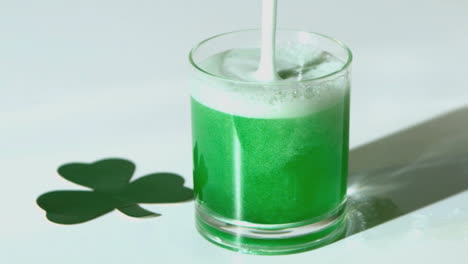 Grünes-Bier-Wird-In-Ein-Glas-Neben-Einem-Kleeblatt-Aus-Papier-Gegossen
