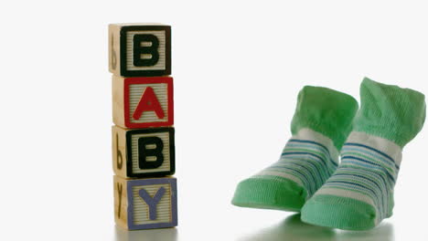 Green-slippers-falling-besides-baby-blocks
