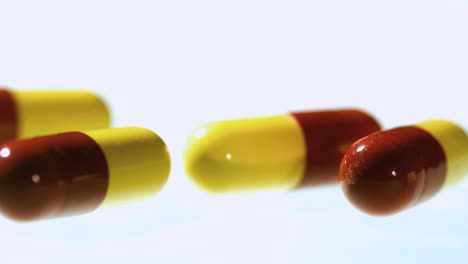 Red-and-yellow-capsule-tablets-falling-and-bouncing-close-up