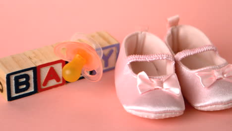 Pink-soother-falling-onto-booties-