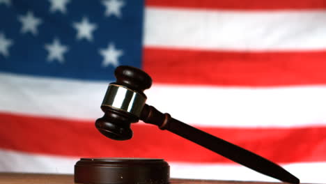 Gavel-dropping-on-sounding-block-with-american-flag-in-background