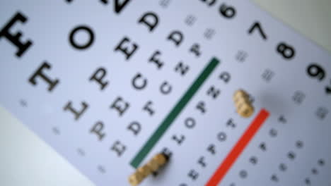 Dice-spelling-out-eye-test-falling-onto-eye-test-beside-glasses