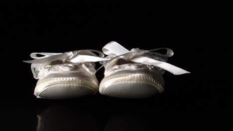 Baby-shoes-falling-and-bouncing-on-black-background