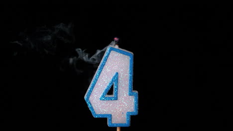 Four-birthday-candle-flickering-and-extinguishing-on-black-background