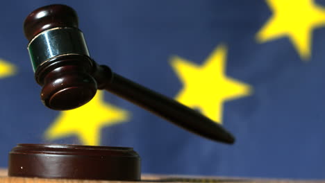Gavel-falling-onto-sounding-block-with-european-union-flag-in-background