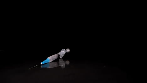 Syringe-falling-and-rolling-towards-camera