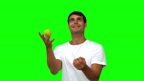 Man-dribbling-with-tennis-balls-on-green-screen