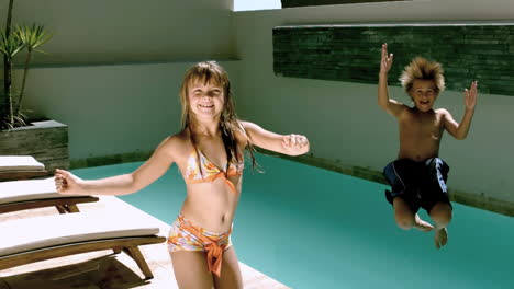 Young-girl-dancing-while-brother-jumping-in-the-swimming-pool