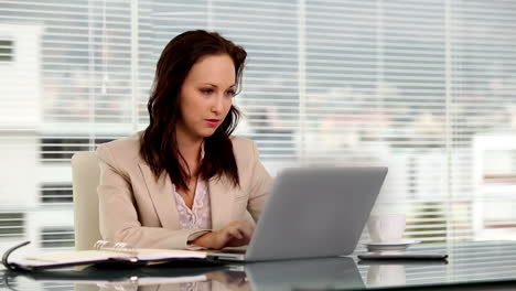 Smiling-businesswoman-using-her-laptop
