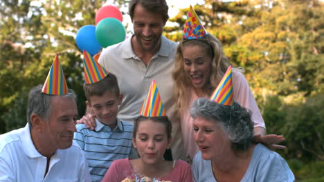 Familia-Feliz-Soplando-Las-Velas-Del-Pastel-De-Cumpleaños-