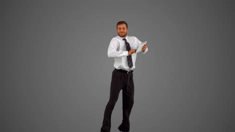 Businessman-holding-digital-tablet-jumping-on-grey-backgroundjumping-