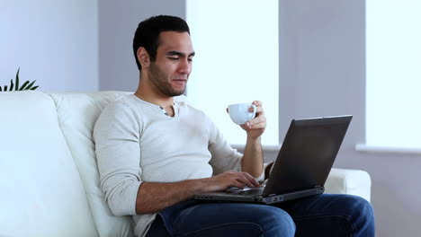 Hombre-Tomando-Un-Café-Mientras-Usa-Una-Computadora-Portátil