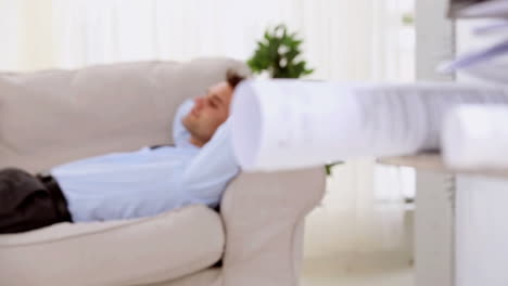Tired-businessman-lying-on-a-sofa-