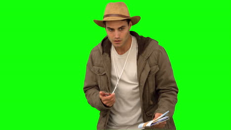 Man-orienteering-with-a-map-and-a-compass-on-green-screen