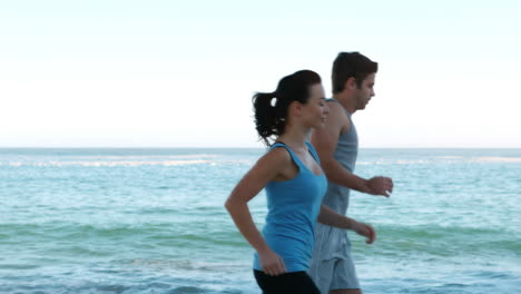 Couple-running-side-by-side-on-the-beach