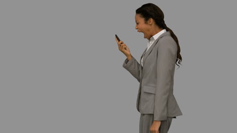 Angry-woman-shouting-at-her-phone-on-grey-screen
