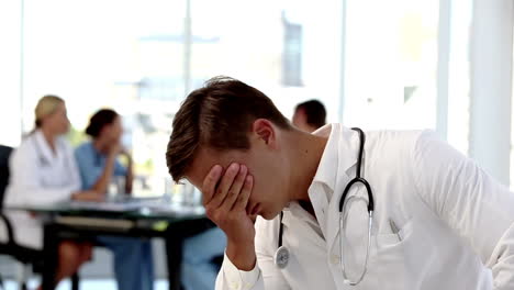 Young-worried-doctor-holding-his-head-