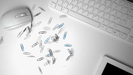 Group-of-paperclips-spilling-onto-office-desk