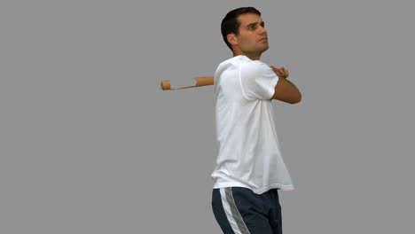 Handsome-man-playing-baseball-on-grey-screen