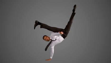 Businessman-doing-one-hand-handstand-on-grey-background