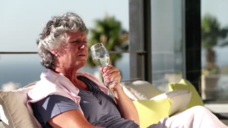 Mature-woman-enjoying-glass-of-wine-on-balcony