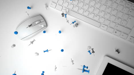 Group-of-pushpins-falling-on-office-desk