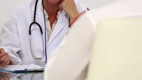 Concentrated-female-doctor-listening-to-her-patient