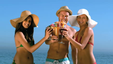 Friends-with-straw-hat-clinking-their-cocktails