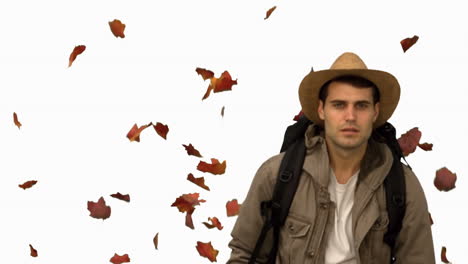 Man-with-a-hat-walking-under-leaves-falling-on-white-screen