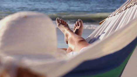 Woman-relaxing-on-the-beach-in-a-hammock