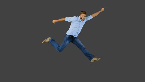 Man-jumping-and-gesturing-on-grey-screen