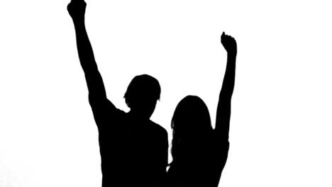 Silhouettes-of-couple-raising-their-arms-on-white-background